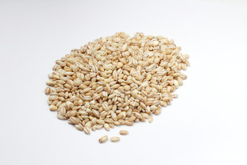 Pearl barley grains on a white background, diet product, natural color, high contrast.