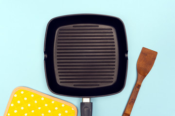 Empty grill pan on bright blue background. Grill food concept