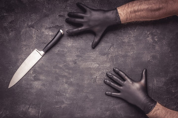 Male Hands with Black Latex Gloves and Knife on Dark Background