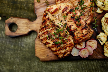 Grilled turkey meat. Steak turkey grill on wooden cutting board with a variety of grilled...