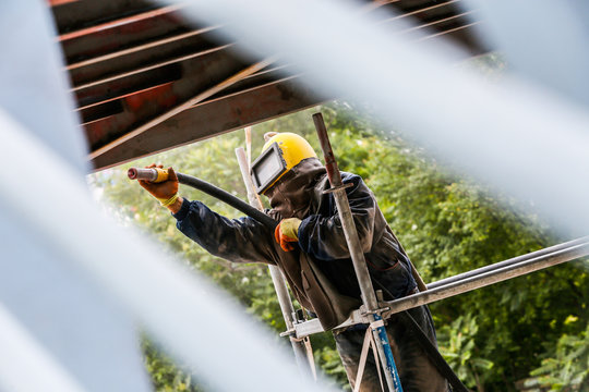 Sand blasting process  Industial worker using sand blasting process preparation cleaning surface on steel before painting