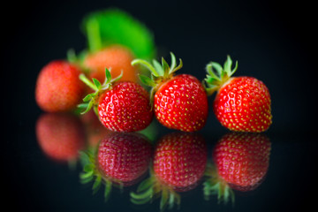 ripe red strawberries on a black background