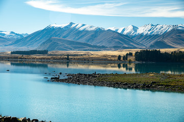 Remarkable landscape of blue lake and snowy mountains background on sunny day at Lake Tekapo, New Zealand.