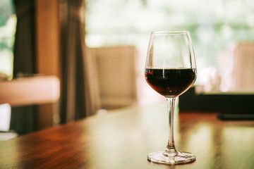 Glass of red wine on table in house. relaxing at home concept.