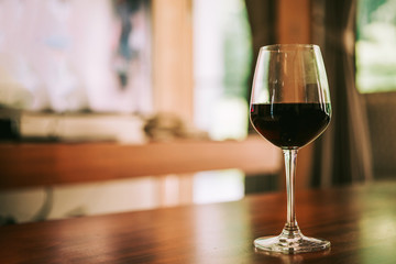 Glass of red wine on table in house. relaxing at home concept.