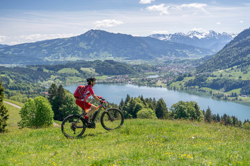 senior woman mountainbiking on a e-mountainbike in early spring, in the Allgaeu Area, a part of the bavarian alps,Germany
