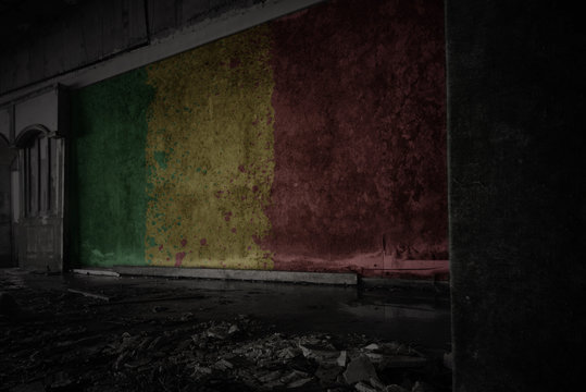 painted flag of mali on the dirty old wall in an abandoned ruined house.