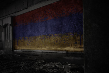 painted flag of armenia on the dirty old wall in an abandoned ruined house.