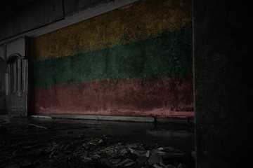 painted flag of lithuania on the dirty old wall in an abandoned ruined house.