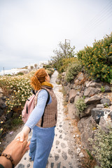 Naklejka premium Couple Traveling. Woman holding hand with Man and leading the Way to New Places