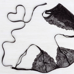 Black Lace bra and panty on white wooden background with heart from ribbon. Female lingerie.Beauty,...