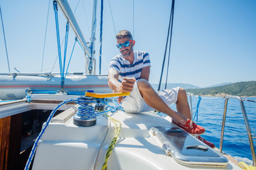 Young man sailing yacht. Holidays, people, travel