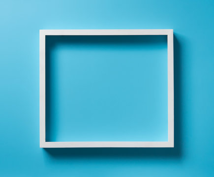 Empty white wood frame with shadow on blue background