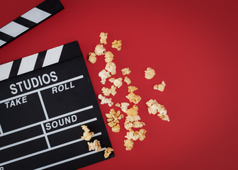 Clapper board with popcorn against red background,Cinema minimal concept,top,view