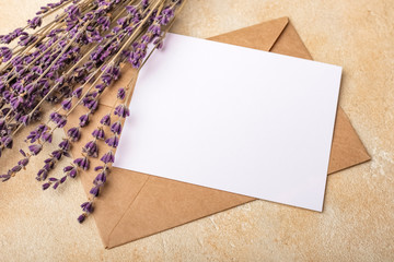  Blank paper with Kraft envelope and lavender flowers on a light background. Simple Wedding...