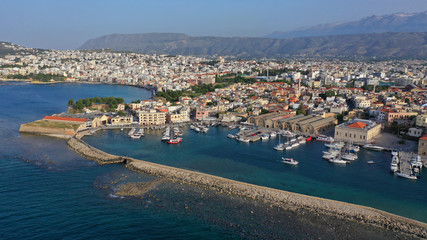 Fototapeta premium Aerial drone photo of iconic Venetian lighthouse in the entrance of picturesque old port of Chania at sunset with beautiful colours, Crete island, Greece