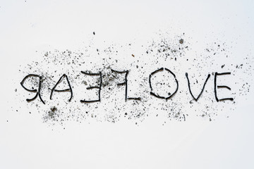 The words love and hate close-up, lined mirror of burnt down matches with ashes around on a white...