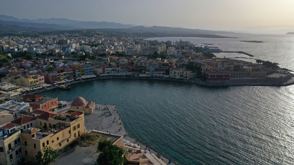 Fototapeta na wymiar Aerial drone photo of iconic Venetian lighthouse in the entrance of picturesque old port of Chania at sunset with beautiful colours, Crete island, Greece