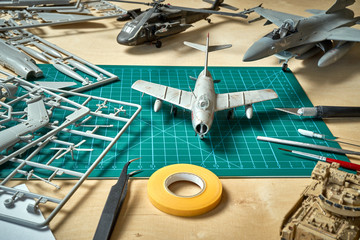 Top view on plastic model scale with accessories on  green pad on  wooden table - obrazy, fototapety, plakaty