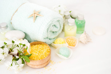 Obraz na płótnie Canvas Aromatic salt for Spa therapies, cosmetics for a body and acceptance of bathtubs, towel and a spring flower. Care of a body. Alternative medicine.