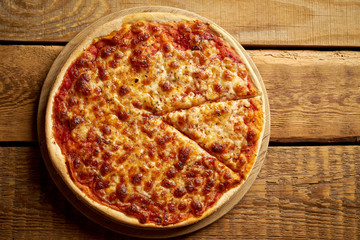 Top view of homemade Italian pizza margherita on old wooden table