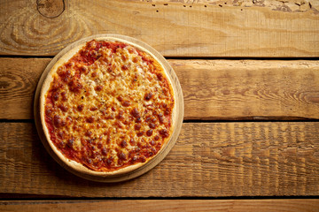 Top view of homemade Italian pizza margherita on old wooden table