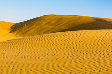 Sand dunes under blue sky