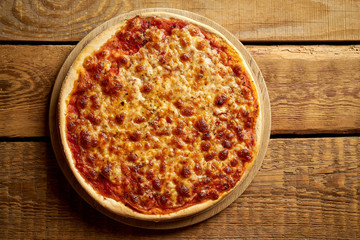 Top view of homemade Italian pizza margherita on old wooden table