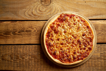 Top view of homemade Italian pizza margherita on old wooden table