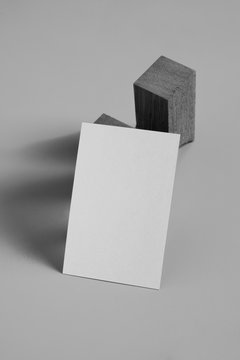 Empty white business card template placed on original wooden stand, black and white picture
