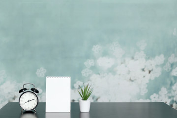 Notepad with place for text, clock, home plant in a pot on the table. The mode of the day, schedule, free and work time.