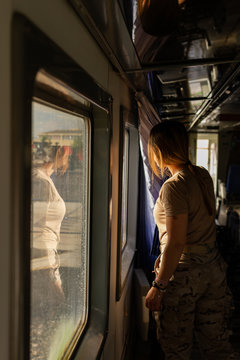 Female soldier looking out window while travelling through countryside in military vehicle