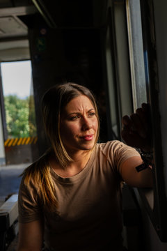 Female soldier looking out window while travelling through countryside in military vehicle