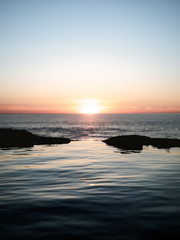 Obraz premium Calm water during sunset on wild beach in Basque Country