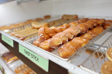 Assorted fresh donuts on display racks at the donut shop.