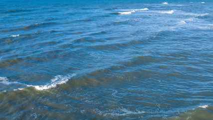 Aerial view of the blue waters of the Mediterranean Sea and specifically of the Tyrrhenian Sea. Sunlight is reflected on the surface of the water.