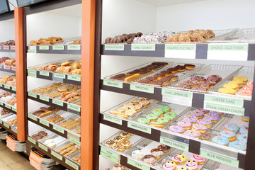 Assorted fresh donuts on display racks at the donut shop.