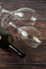 Dark bottle of wine and glasses on wooden background. Top view.