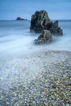Beautiful landscape of Playa de Gueirua seashore with rocks on foggy day at Asturias, Spain