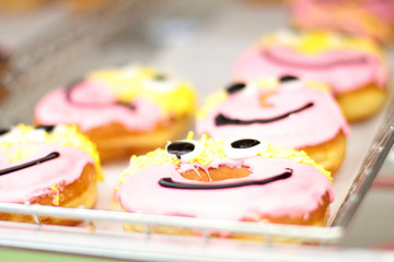 Fresh donuts on display racks at the donut shop.