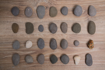 Sea stones arranged in rows. River stones on a wooden background. Smooth stones.