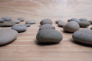 Fototapeta na wymiar Sea stones arranged in rows. River stones on a wooden background. Smooth stones.