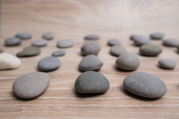 Fototapeta na wymiar Sea stones arranged in rows. River stones on a wooden background. Smooth stones.