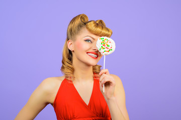 Lollipop. Sweet food. Sweets. Dessert. Smiling woman covering eye by lollipop. Pin up woman with lollipop in hand. Sexy girl with colourful candy. Candy store. Candy shop. Candy bar.