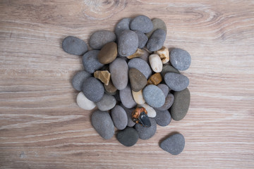 Fototapeta premium A bunch of sea stones. River stones on a wooden background. Smooth stones.