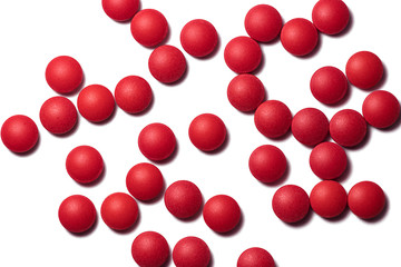 Lots of red round pills on white background