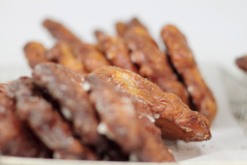 Apple fritters on display racks at the donut shop.