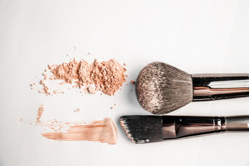 powder slide, a touch of foundation and two black makeup brushes