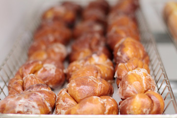 Fresh donuts on display racks at the donut shop.