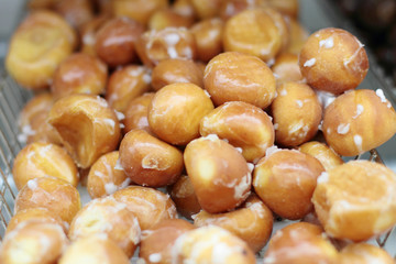 Donut holes on display racks at the donut shop.